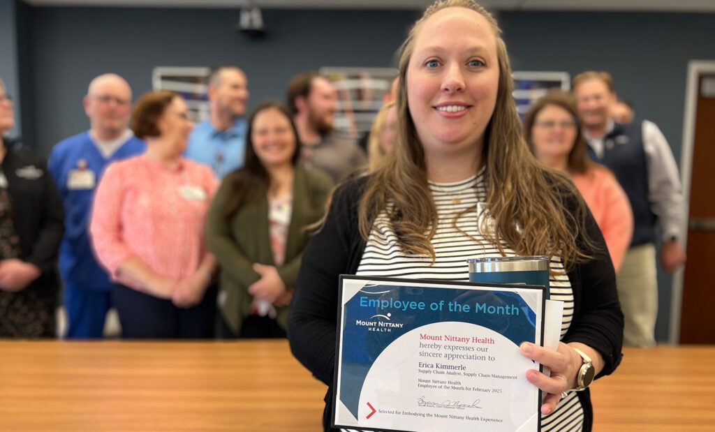 Erica Kimmerle poses with her employee of the month certificate in front of her coworkers